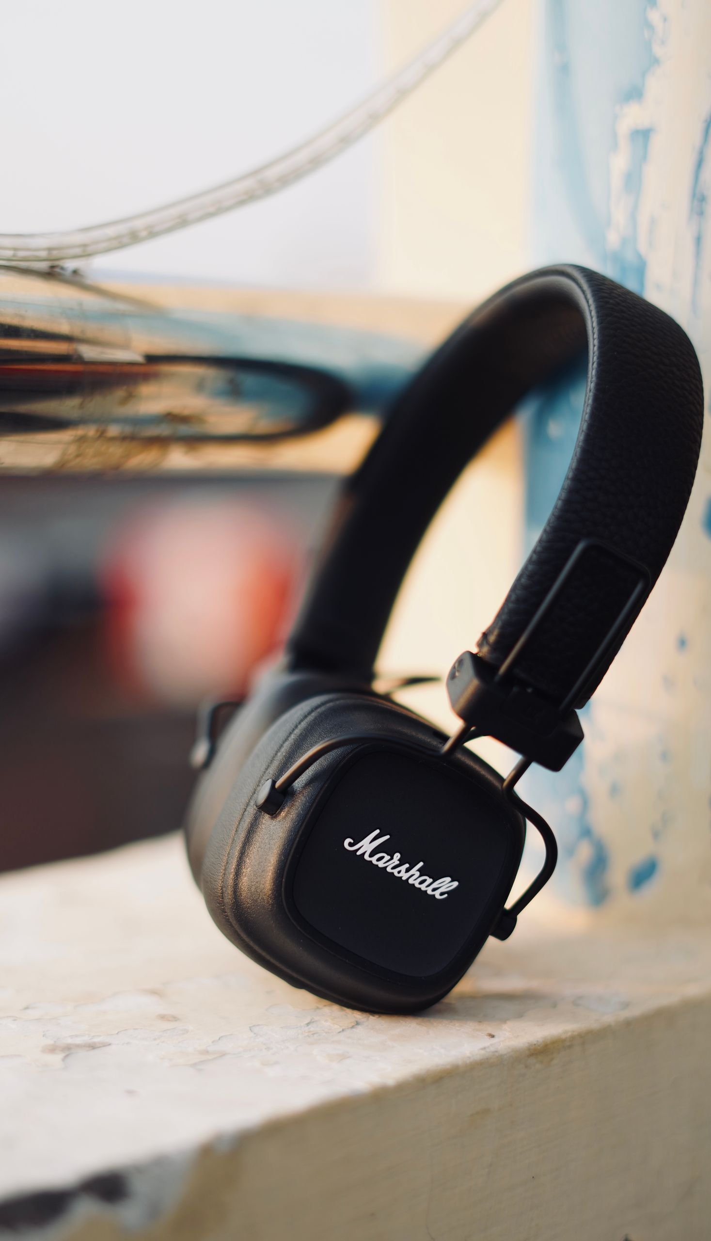 Sleek black wireless headphones resting on an urban ledge, perfect for music enthusiasts on the go.
